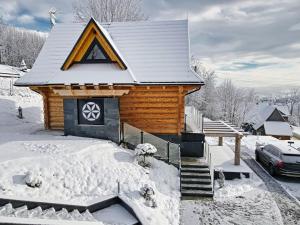 a log cabin with a snow covered roof at Malczykówka-luksusowy dom & SPA, z widokiem na Tatry in Bukowina Tatrzańska