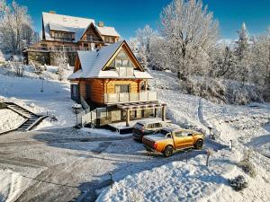 Un camión estacionado frente a una casa en la nieve. en Malczykówka-luksusowy dom & SPA, z widokiem na Tatry, en Bukowina Tatrzańska
