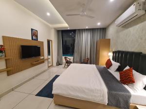 KaithalMahadev Residency的一间配有床和平板电视的酒店房间