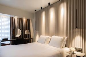 a bedroom with a large white bed and a window at Brasil Suites Boutique Hotel in Athens +37 photos