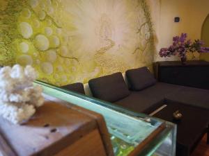 a living room with a couch and a wall with grapes at Penzion Avalon in Valtice