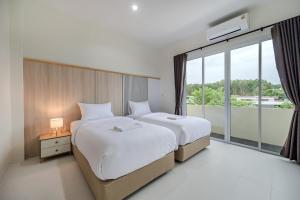 two beds in a hotel room with a large window at Sea eagle Triple house 7 bedrooms in Aonang in Ao Nang  +72 photos
