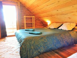 Un dormitorio con una cama en una cabaña de troncos en Magnifique chalets en rondins avec SPA et Tipis en plaine Nature Environnement ressourçant au calme vue imprenable Lascaux SPA non disponible juillet et aout, en Les Farges