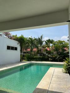 a swimming pool in front of a building with palm trees at Ripasso Bed & Breakfast in Malindi