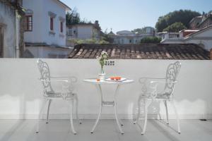 two chairs and a table with a vase of flowers at 鼓浪屿吕舍民宿 in Gulang Yu