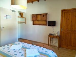 a small room with a bed and a television at Auberge La maison de Catherine in Puy-Saint-Pierre