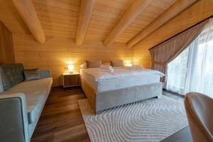 una camera da letto con un letto e un divano in una stanza di Royal Chalet Donovaly a Donovaly
