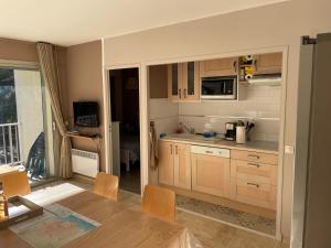 a kitchen with wooden cabinets and a dining table at Bandol - Plage de Renécros in Bandol
