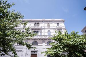 a white building with trees in front of it at Palazzo Zippitelli Apartments in Bari