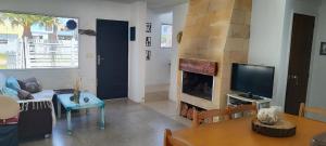 Una sala de estar con chimenea y televisión. en YellowStone, en Balneario Buenos Aires