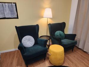 two chairs and a table in a living room at Seogwipo Hineni Private House in Seogwipo