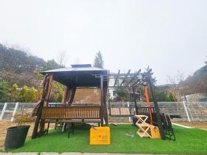 a gazebo with a bench and umbrella on the grass at Damyang Secret Garden Pet-friendly Private Pension in Damyang +2 photos