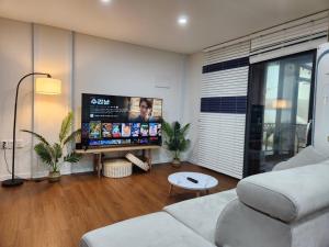 a living room with a couch and a flat screen tv at Paju Heyri Hills Modern House in Paju