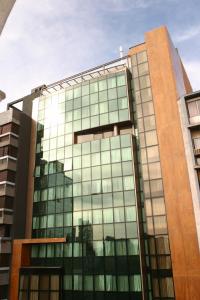 a tall glass building with a lot of windows at King David Flat Hotel - Argentina in Cordoba