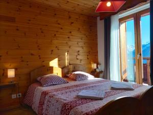 a bedroom with a bed with a wooden wall at Auberge La maison de Catherine in Puy-Saint-Pierre