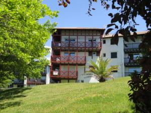 ein Gebäude mit einem Balkon an der Seite in der Unterkunft Appt vue golf dans résidence avec piscine in Bassussarry + 1 Foto