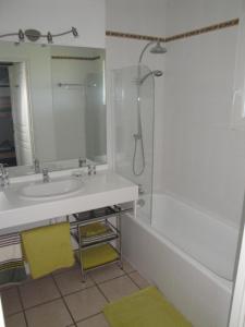 ein Badezimmer mit Waschbecken und Dusche in der Unterkunft Appt vue golf dans résidence avec piscine in Bassussarry