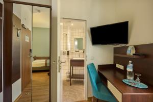 Uma TV ou centro de entretenimento em Trip Inn Hotel Messe Westend