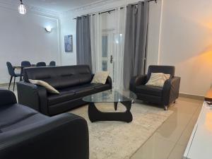 a living room with couches and a table and chairs at Appartements modernes, Wifi, TV - Yaoundé, Omnisports in Yaoundé +45 photos