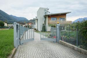 a gate in front of a house with a house at Casa Montesei di TSS' -Ampio, di classe, vista e posto auto in Pergine Valsugana