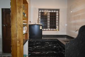a kitchen with a black counter and a window at Vill Brahmi Stay Gokarna in Gokarn