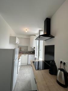 a kitchen with white cabinets and a black counter top at Appartement Centre ville in Vierzon