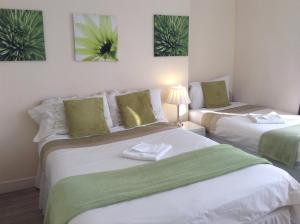 two beds in a room with green and white at Citadel House Hotel in Plymouth