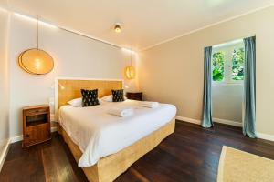 a bedroom with a large bed and a window at La Garçonniere in Saint-Pierre +138 photos