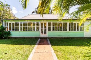 a green house with a palm tree in front of it at La Garçonniere in Saint-Pierre