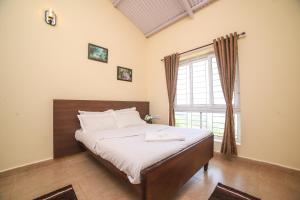 a bedroom with a large bed with a window at The Springs by Indo Stays in Yedapalli