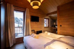 La Plagne TarentaiseにあるChalet Fend l'air - Plagne 1800 - 12 personnes - skis au Piedのベッドが2つと大きな窓がある寝室