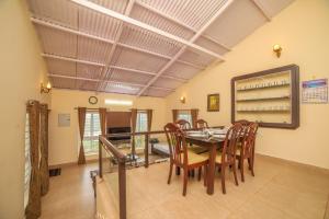 a dining room with a table and chairs and a mirror at The Springs by Indo Stays in Yedapalli