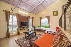 a living room with a couch and a tv at The Springs by Indo Stays in Yedapalli