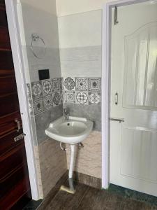 a white sink in a bathroom with a door at Choudhury's Stay Barpeta Road in Helāpākari