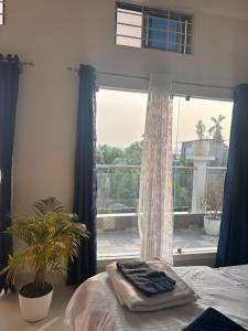 a bedroom with a bed and a large window at Choudhury's Stay Barpeta Road in Helāpākari +2 photos