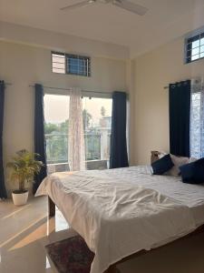 a bedroom with a large bed and a large window at Choudhury's Stay Barpeta Road in Helāpākari