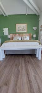 a large bed in a room with green walls at The Amaryllis Luxury Apartment Bella Donna in Bettyʼs Bay