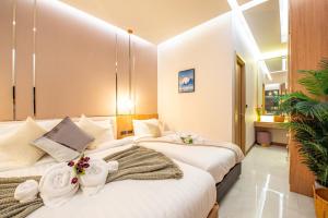 two beds in a hotel room with towels on them at Anya pool villa pattaya in Ban Huai Yai +41 photos