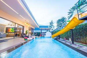 a pool with a slide in a house at Anya pool villa pattaya in Ban Huai Yai
