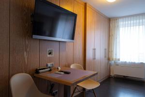 a room with a table and a television on a wall at Hotel & Apartments Böhm in Gravenwerth