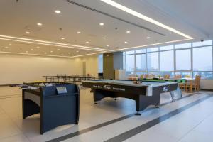 two ping pong tables in a large room with windows at SIMI Homes Lancaster 24 Cozy Studio for 4 in Luxury Building with Heated Pool, Fitness and Spa Hanoi Center in Hanoi +63 photos