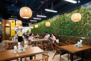 a restaurant with wooden tables and people sitting at them at SIMI Homes Lancaster 24 Cozy Studio for 4 in Luxury Building with Heated Pool, Fitness and Spa Hanoi Center in Hanoi