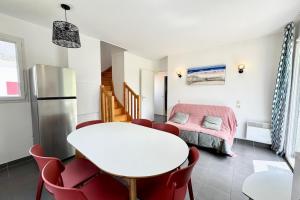 a room with a white table and chairs and a bed at Maisonnette tout confort - Golf - Piscine in Quéven