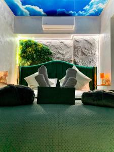 a bedroom with a green bed with pillows and a ceiling at Golden Station Ultraconfort in Iaşi