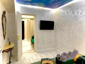 a living room with a tv on a white wall at Golden Station Ultraconfort in Iaşi