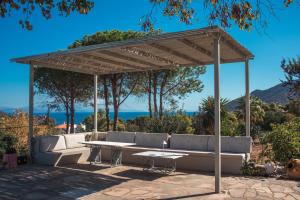 a wooden pavilion with a table and benches at Hippie Bay Complex in Porto Rafti +104 photos