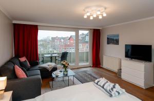 a living room with a couch and a tv at Apartment Di Wiis in Westerland (Sylt)