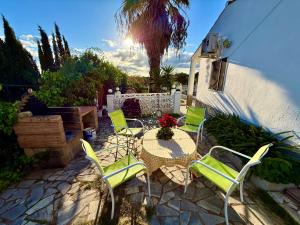 patio z zielonymi krzesłami i stołem z ozdobą kwiatów w obiekcie La Blanca de Aroche w mieście Aroche
