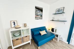 a living room with a blue chair and a table at Maisonnette tout confort proche plages et bourg in Port-Louis