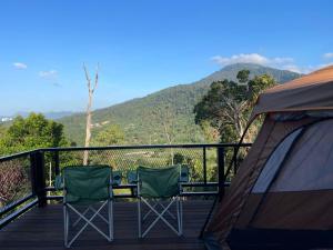 two chairs sitting on a deck with a tent at OYO 91261 Thebukit, Langkawi in Kuah